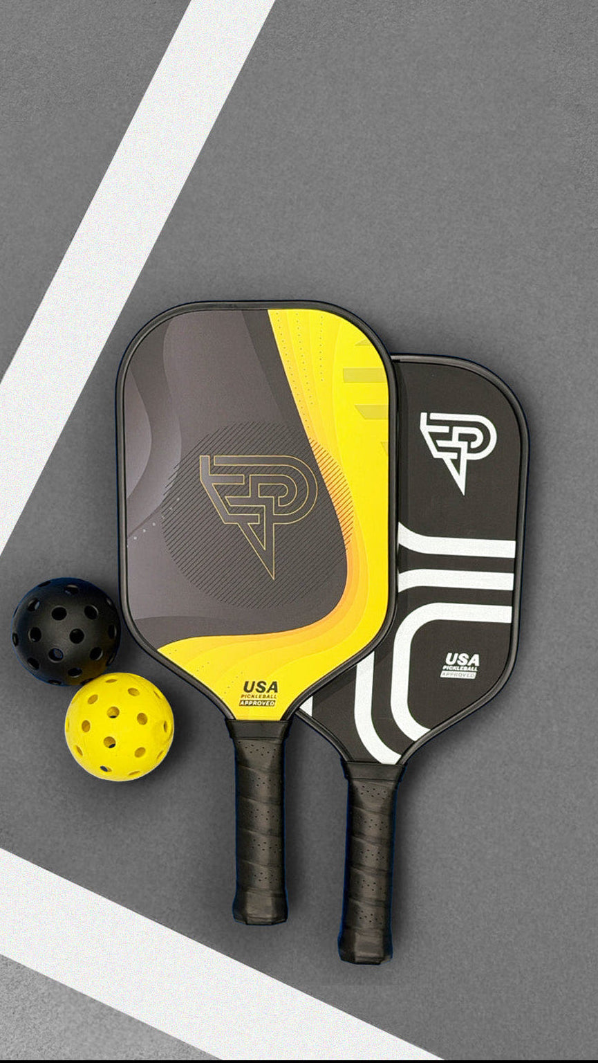 Two pickleball paddles with a ball on a gray surface